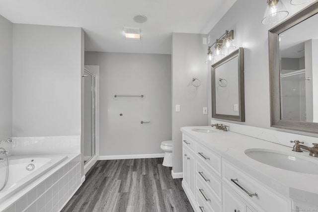 bathroom with wood finished floors, a sink, a bath, and a shower stall