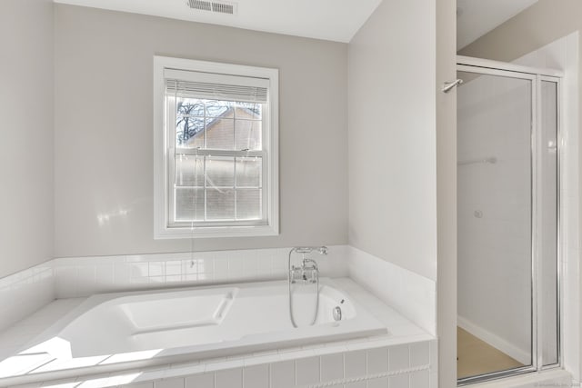 bathroom with visible vents, a garden tub, and a shower stall