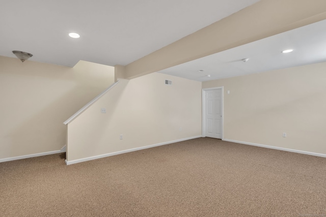 basement with carpet, visible vents, and baseboards