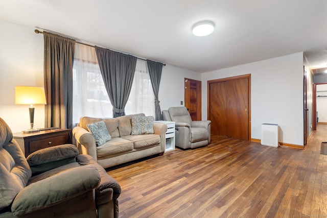 living area featuring wood-type flooring and baseboards