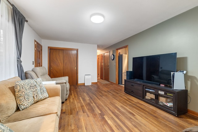 living room with wood-type flooring and baseboards