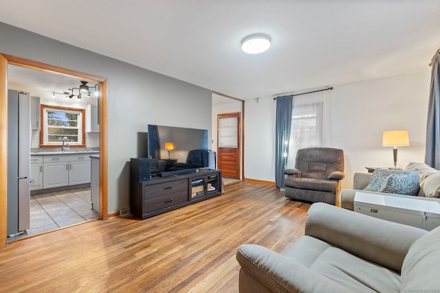 living area with light wood-style flooring and baseboards