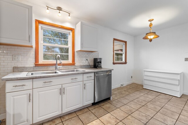 kitchen featuring white cabinets, decorative backsplash, dishwasher, light countertops, and a sink