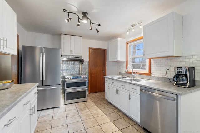 kitchen with stainless steel appliances, white cabinetry, a sink, and under cabinet range hood