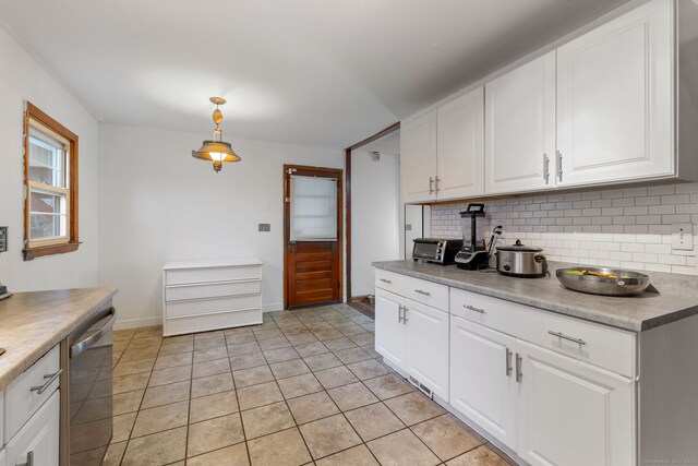 kitchen featuring decorative light fixtures, decorative backsplash, stainless steel dishwasher, white cabinetry, and light tile patterned flooring