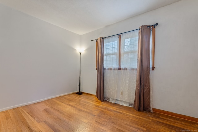 empty room with baseboards and light wood-style floors