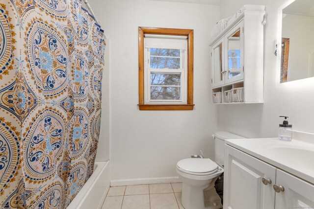 bathroom with baseboards, toilet, tile patterned floors, shower / bathtub combination with curtain, and vanity