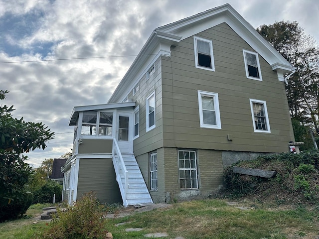 exterior space featuring stairs and a sunroom