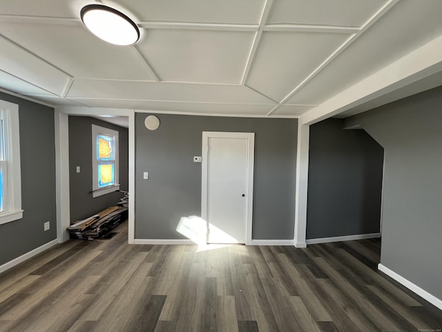 spare room featuring dark wood-style floors and baseboards