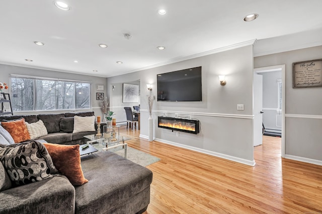 living area with wood finished floors, a glass covered fireplace, and recessed lighting