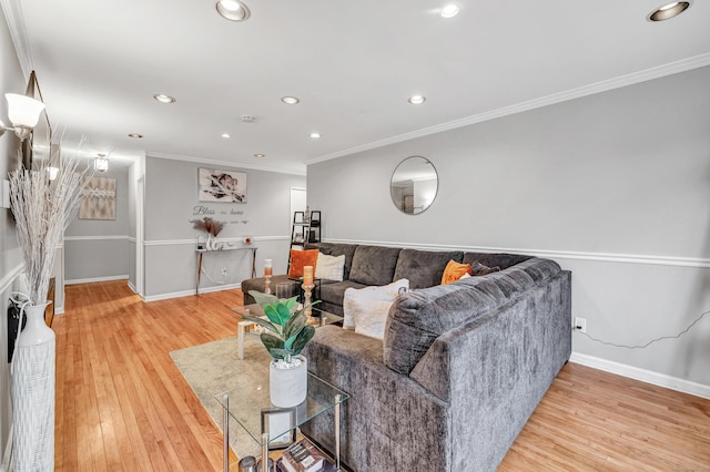 living room with ornamental molding, light wood-type flooring, and baseboards