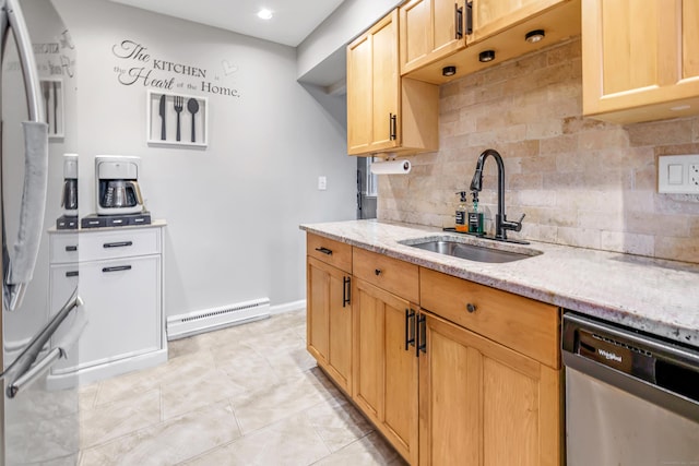 kitchen featuring light stone counters, a baseboard heating unit, stainless steel appliances, a sink, and backsplash