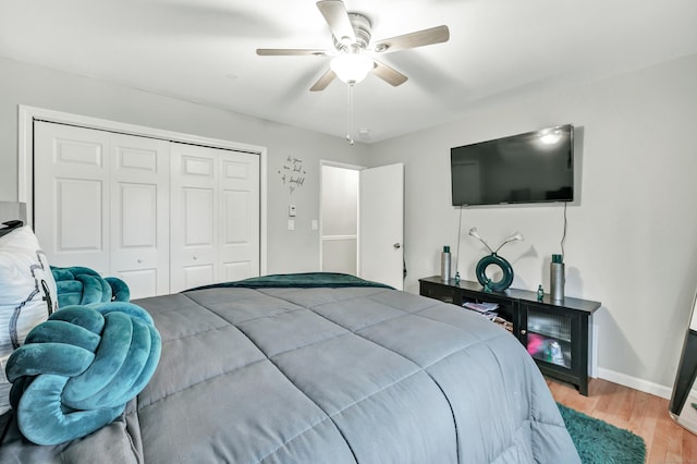 bedroom featuring light wood-type flooring, ceiling fan, baseboards, and a closet