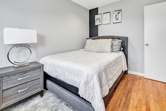 bedroom featuring baseboards and wood finished floors