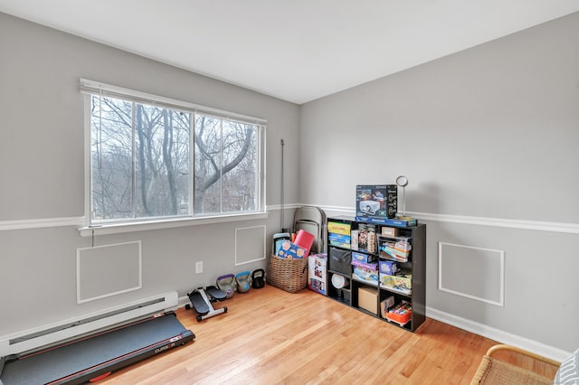 recreation room featuring a baseboard radiator and wood finished floors