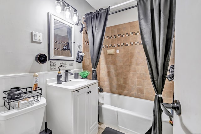 full bathroom featuring a wainscoted wall, toilet, shower / bath combination with curtain, and vanity