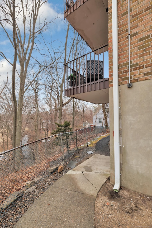 view of patio featuring fence and a balcony