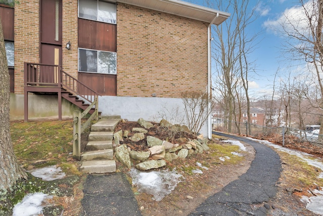 view of home's exterior featuring fence and brick siding