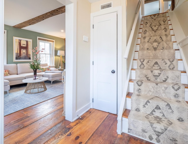 entryway featuring visible vents, stairway, baseboards, and hardwood / wood-style flooring