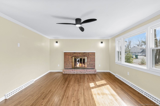 unfurnished living room featuring baseboards, crown molding, baseboard heating, and wood finished floors