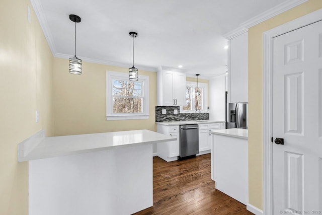 kitchen featuring appliances with stainless steel finishes, dark wood-style flooring, crown molding, white cabinetry, and a sink