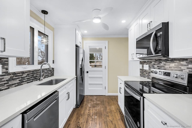 kitchen with stainless steel appliances, light countertops, a sink, and ornamental molding