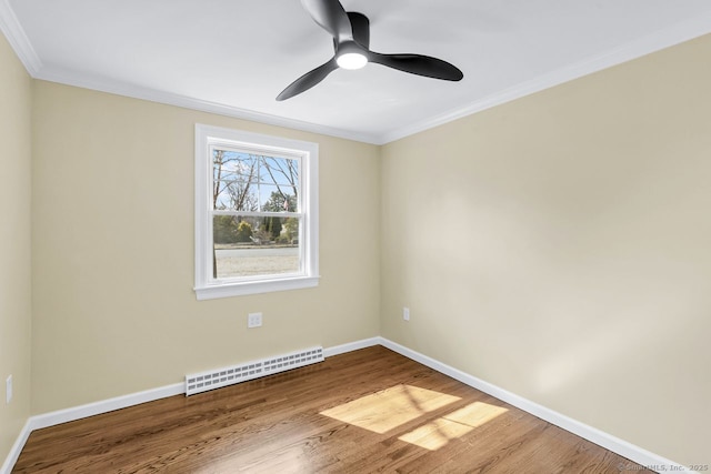 unfurnished room with crown molding, a baseboard heating unit, wood finished floors, and baseboards