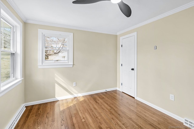 empty room with a baseboard radiator, wood finished floors, visible vents, baseboards, and ornamental molding