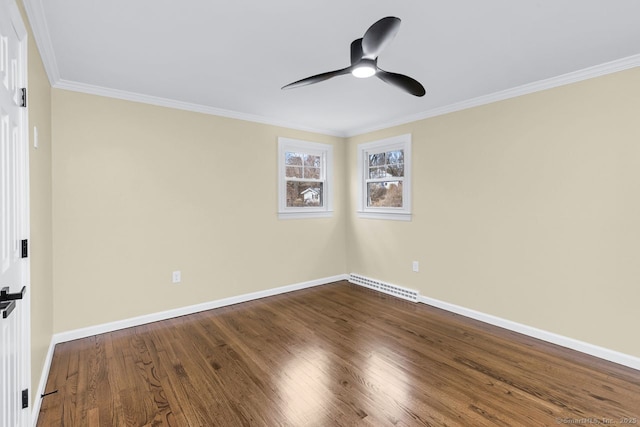 empty room with crown molding, dark wood-style flooring, visible vents, and baseboards