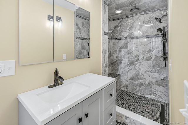 full bathroom featuring a tile shower and vanity