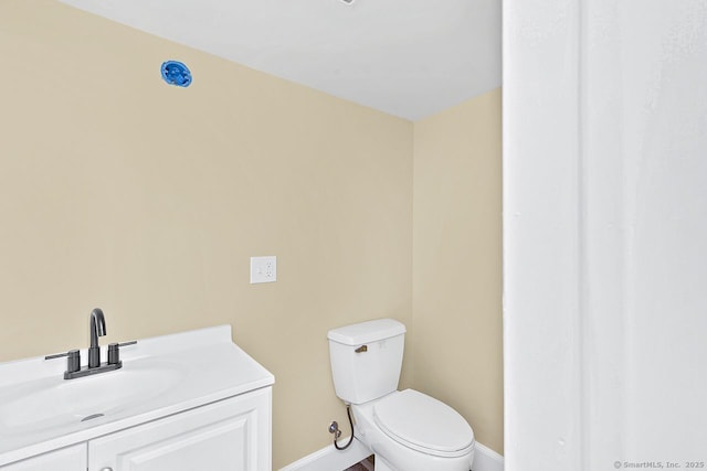 bathroom featuring vanity, toilet, and baseboards