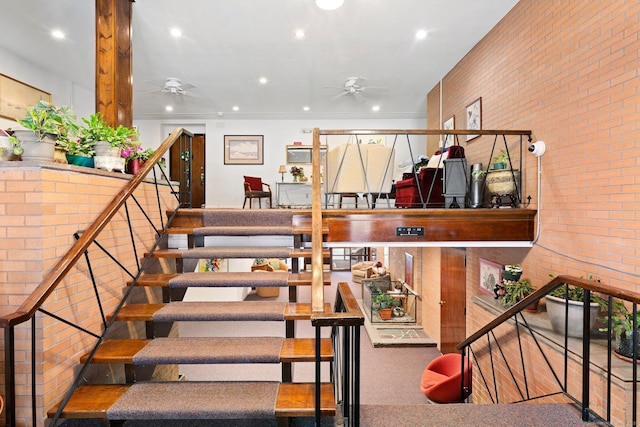 staircase featuring brick wall, ceiling fan, and recessed lighting