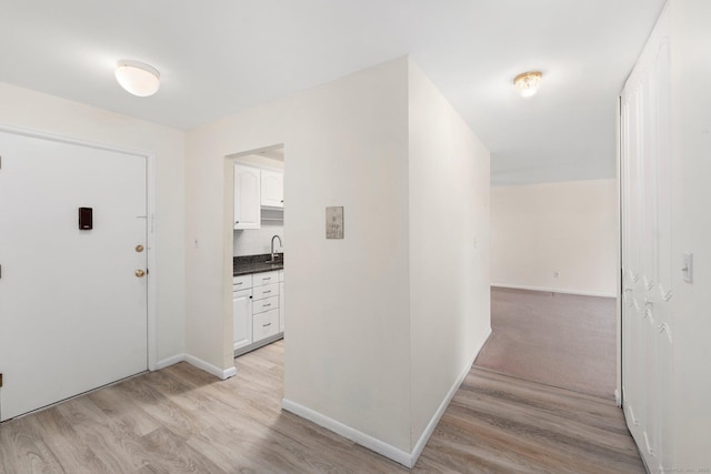 foyer entrance featuring light wood-style floors and baseboards