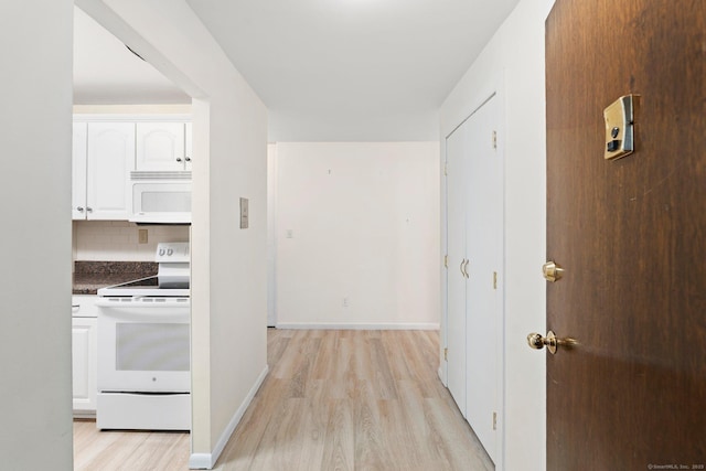 corridor featuring light wood-type flooring and baseboards