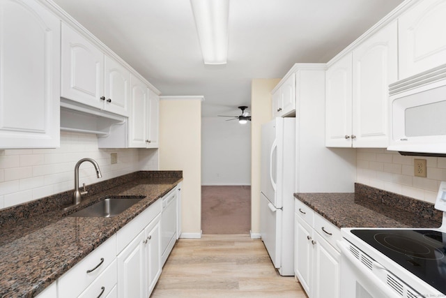 kitchen with white appliances, white cabinets, a sink, and ceiling fan