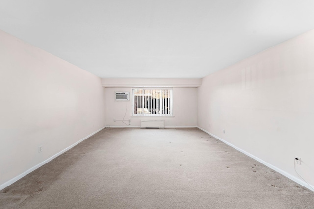 unfurnished room featuring carpet, an AC wall unit, and baseboards