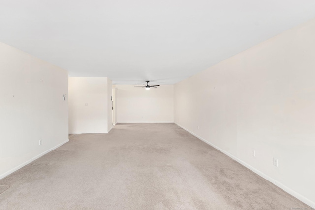 empty room with light carpet, ceiling fan, and baseboards