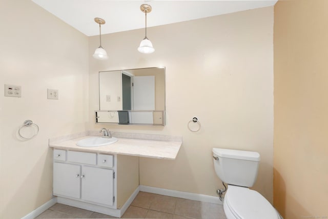 bathroom featuring baseboards, vanity, toilet, and tile patterned floors