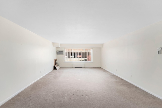 unfurnished living room with light carpet, a wall mounted AC, and baseboards