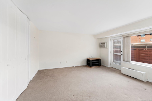 carpeted spare room featuring a wall mounted air conditioner and baseboards