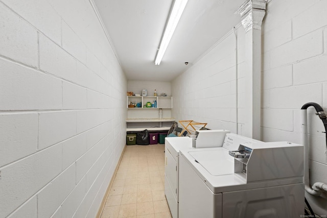 common laundry area with washer and dryer and concrete block wall