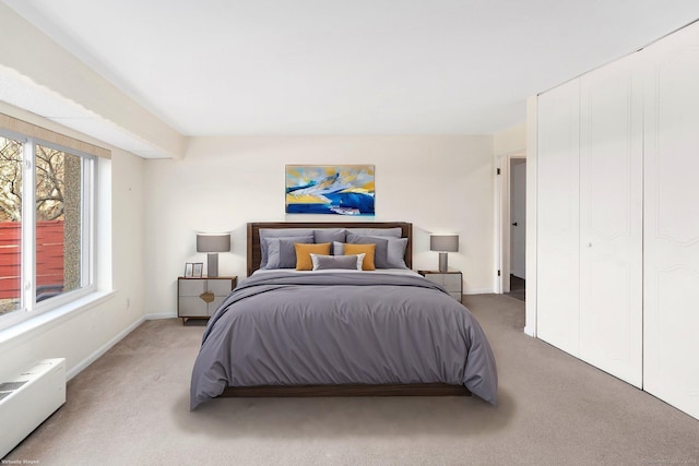 bedroom featuring radiator, light carpet, and baseboards