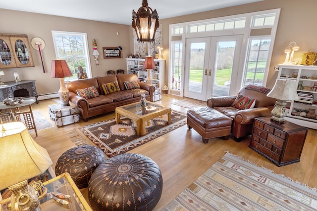 living room with french doors, baseboard heating, wood finished floors, and a notable chandelier