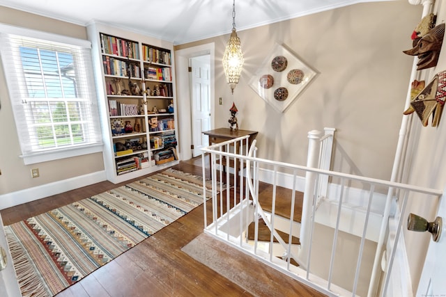 hall featuring an upstairs landing, crown molding, baseboards, and hardwood / wood-style flooring