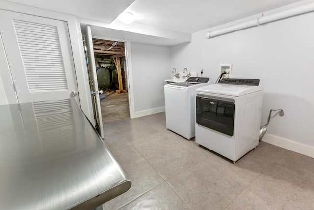 clothes washing area featuring washing machine and dryer and baseboards