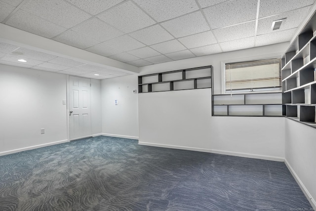 spare room with carpet floors, baseboards, visible vents, and a paneled ceiling