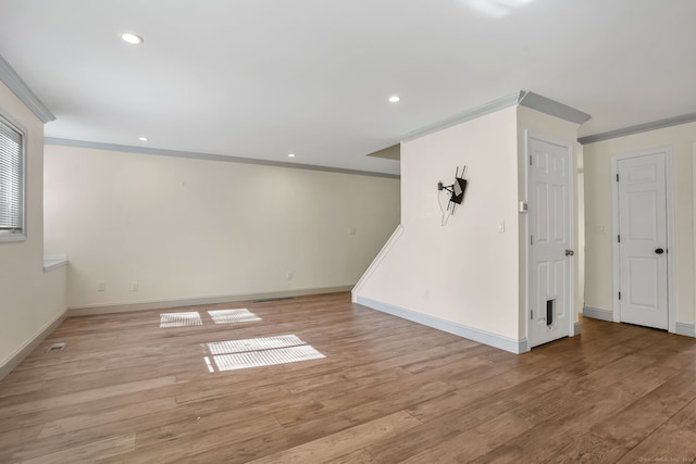 interior space featuring baseboards, ornamental molding, light wood-type flooring, and recessed lighting