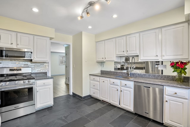 kitchen featuring appliances with stainless steel finishes, a sink, and white cabinetry