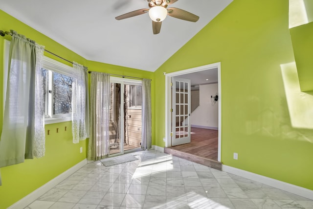 spare room featuring a ceiling fan, marble finish floor, high vaulted ceiling, and baseboards