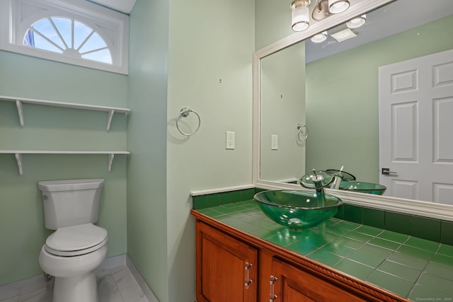 bathroom with toilet, marble finish floor, baseboards, and vanity